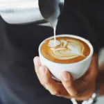 person performing coffee art