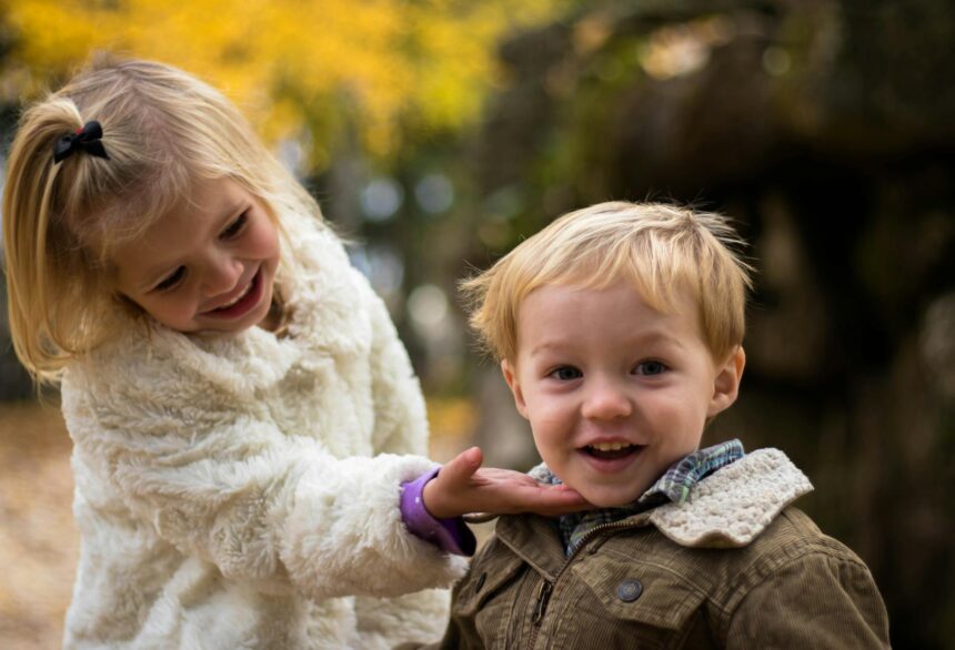girl holding the chin of boy outdoor