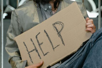 person in gray shirt holding brown cardboard