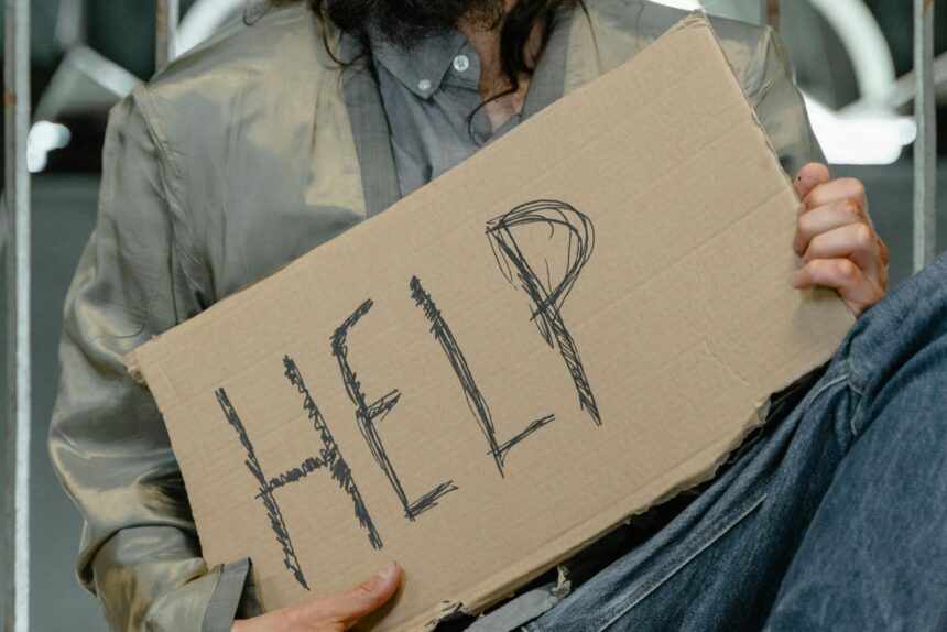 person in gray shirt holding brown cardboard