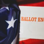 A mail-in ballot form displayed over an American flag.