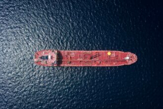 Aerial view of an oil tanker at sea, illustrating shipping risks around the Strait of Hormuz