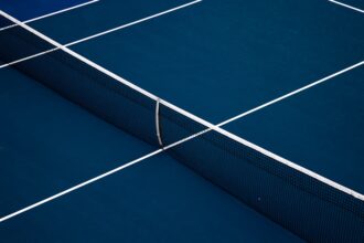 Blue hard-court tennis surface illustrating Ben Shelton’s late-night U.S. Open victory.