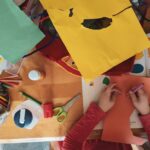 Child creating an art project at a table with colorful craft supplies