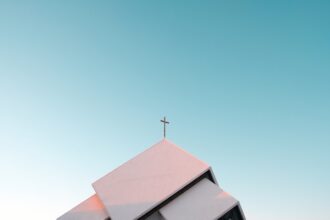 Church cross against the sky, illustrating a religious-conscience dispute involving Catholic healthcare providers
