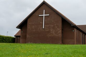 Church exterior with a cross, representing houses of worship