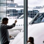 Family looking at an airplane through an airport terminal window