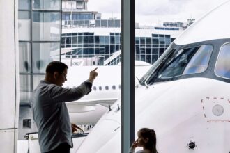 Family looking at an airplane through an airport terminal window