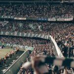 Fans watching a sporting event in a stadium at night