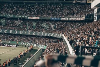 Fans watching a sporting event in a stadium at night