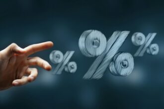 Hand reaching toward percentage symbols representing changing interest rates