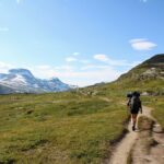 Hiker walking through a mountain landscape.