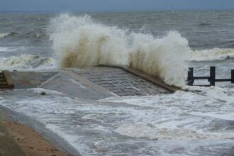 Large storm waves striking a coastal seawall during a nor’easter
