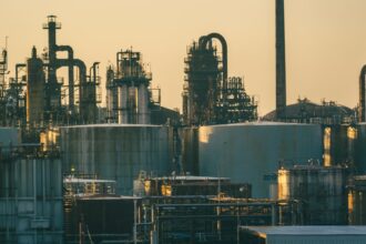 Oil refinery and storage tanks under a golden sky