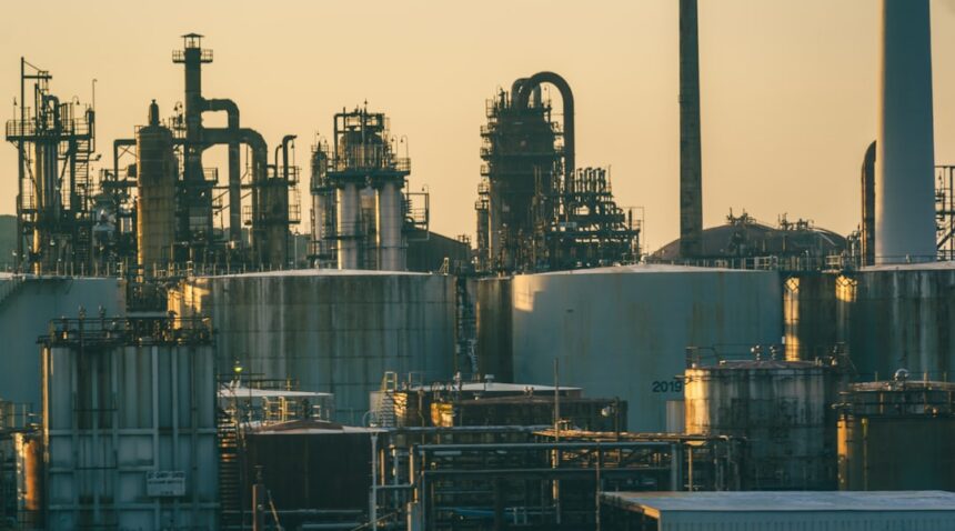 Oil refinery and storage tanks under a golden sky