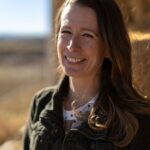 Oregon mother Jessica Bates smiling beside hay bales at her home in Malheur County.