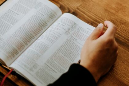 Pastor studying an open Bible at a wooden table