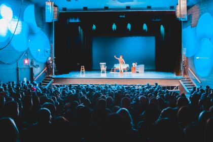 Performers on a brightly lit theater stage, illustrative image
