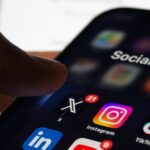 Person holding a smartphone displaying social media apps