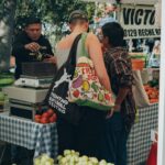 Shoppers gathered around a farmers market fruit stand