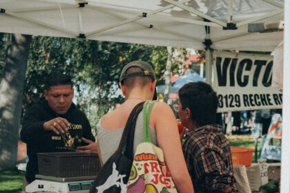 Shoppers gathered around a farmers market fruit stand