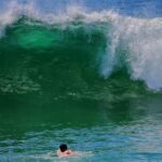 Surfer riding elevated ocean waves during hazardous surf conditions