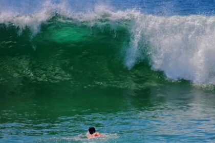 Surfer riding elevated ocean waves during hazardous surf conditions