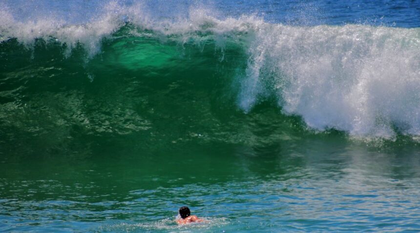 Surfer riding elevated ocean waves during hazardous surf conditions