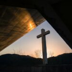 White cross at sunrise illustrating the death and resurrection of Jesus Christ