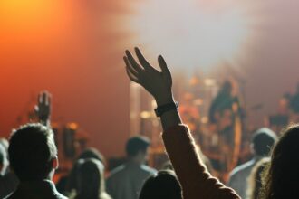 Young adults raising their hands during a worship gathering