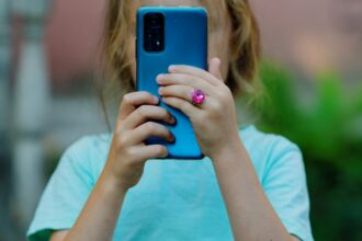Young girl using a smartphone, illustrating child privacy concerns