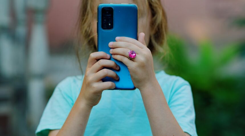 Young girl using a smartphone, illustrating child privacy concerns