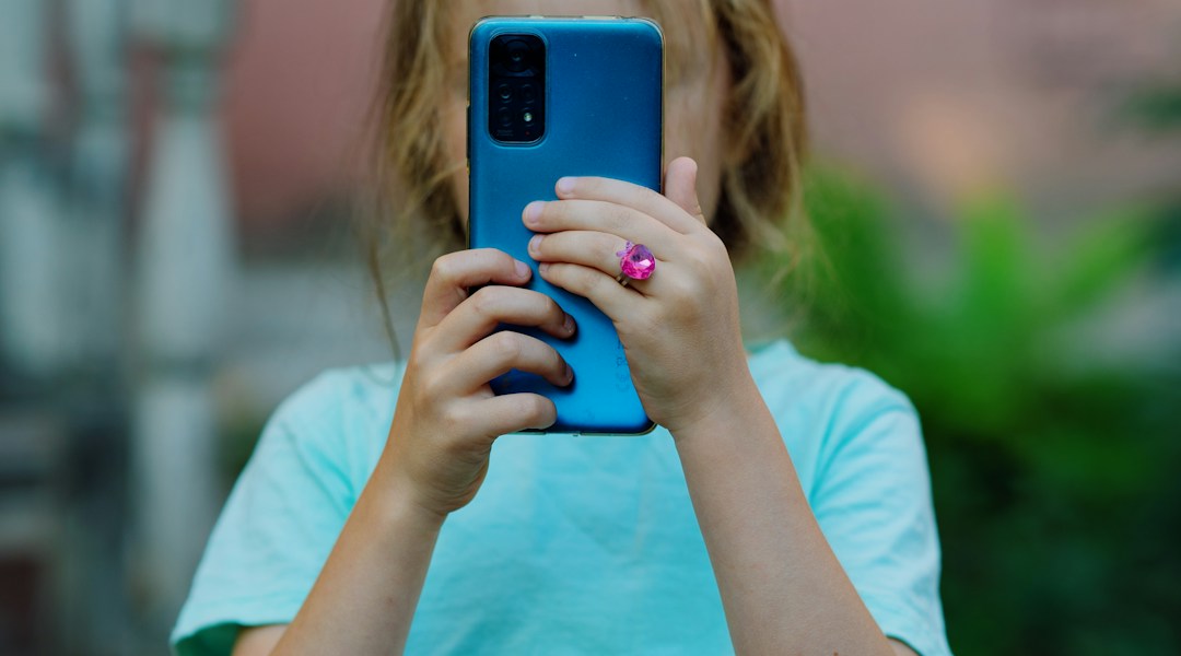Child using a smartphone, illustrating online privacy concerns