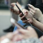 Young person holding a smartphone representing teen social media use