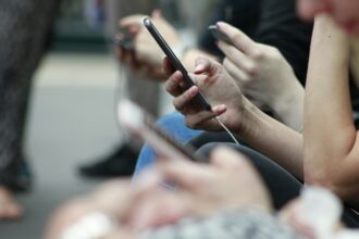 Young person holding a smartphone representing teen social media use