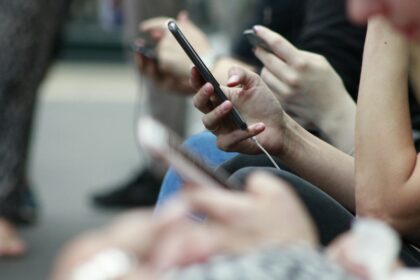 Young person holding a smartphone representing teen social media use