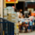 Blue shopping cart in a grocery store aisle; illustrative photograph.