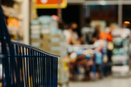 Blue shopping cart in a grocery store aisle; illustrative photograph.