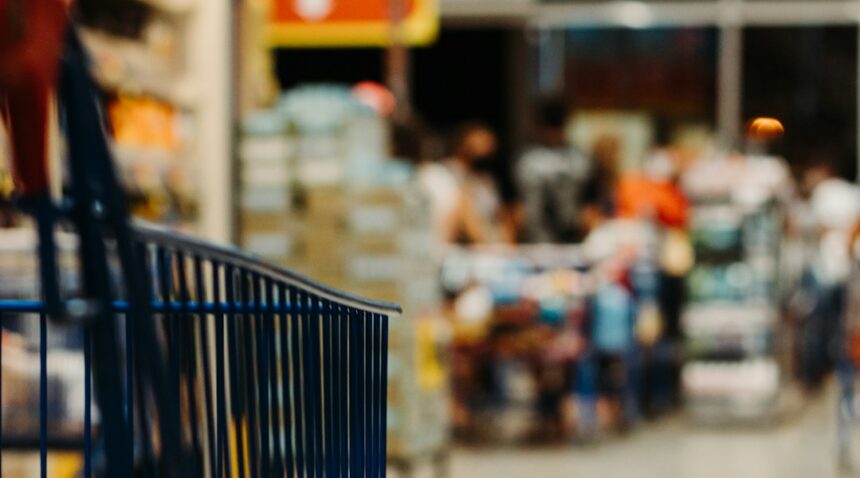 Blue shopping cart in a grocery store aisle; illustrative photograph.