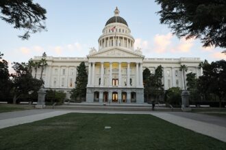California State Capitol in Sacramento beneath a clear evening sky.
