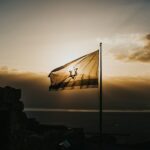 Israeli flag silhouetted against the sky; illustrative photograph