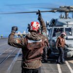 Navy sailor guides a helicopter aboard USS Theodore Roosevelt; September 29, 2026 file photo