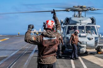 Navy sailor guides a helicopter aboard USS Theodore Roosevelt; September 29, 2026 file photo