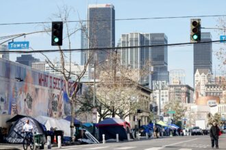 Skid Row in downtown Los Angeles with tents and the downtown skyline in the background