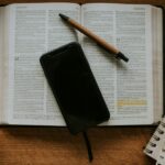Smartphone resting on an open notebook; illustrative photograph for a story on faith and digital life.
