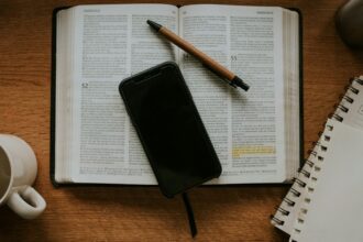 Smartphone resting on an open notebook; illustrative photograph for a story on faith and digital life.
