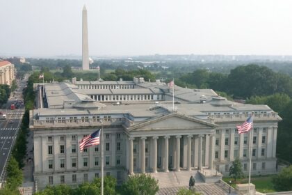 U.S. Treasury building in Washington, D.C., with the Washington Monument in the background, photographed in July 2015.